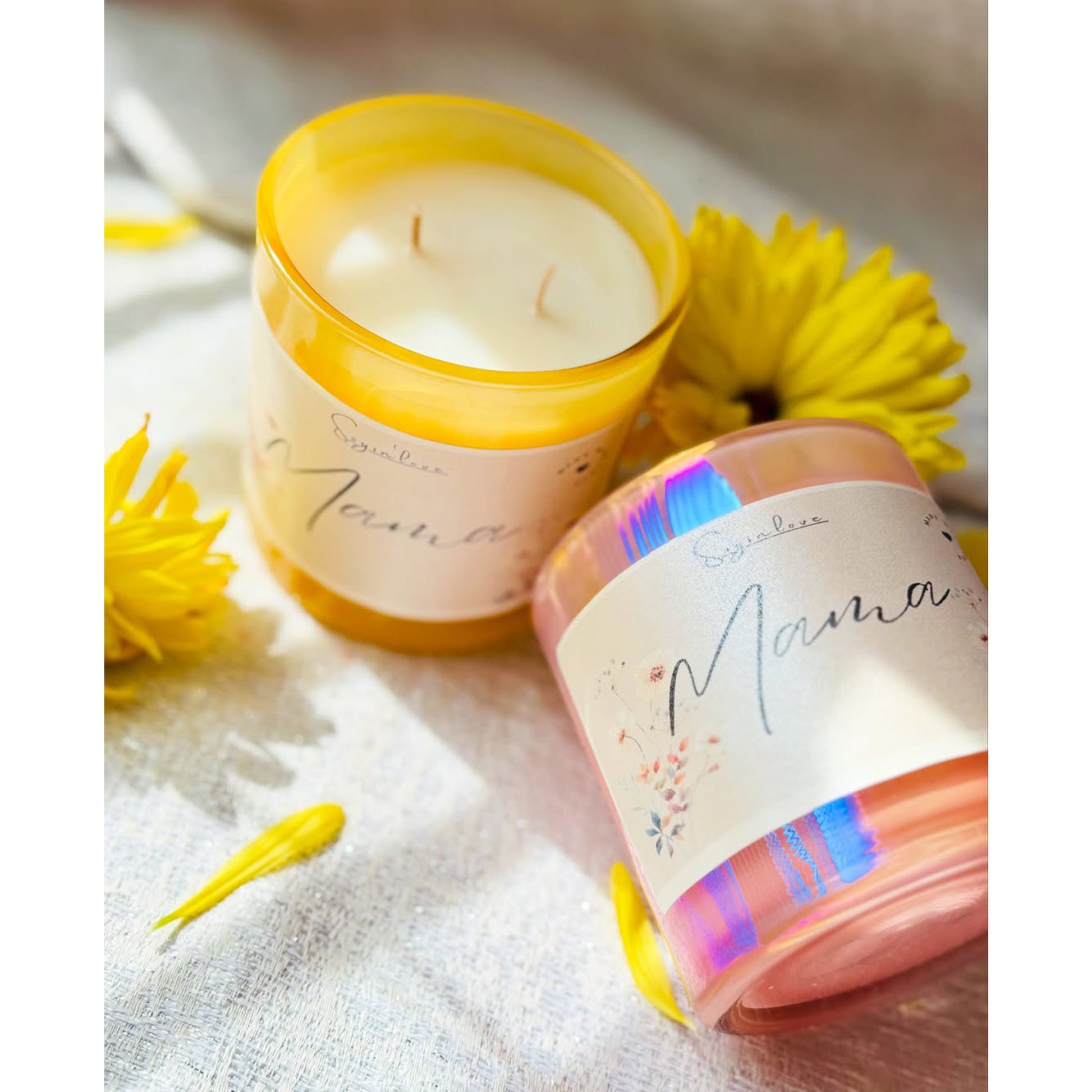 Two candles with colorful labels and yellow flowers